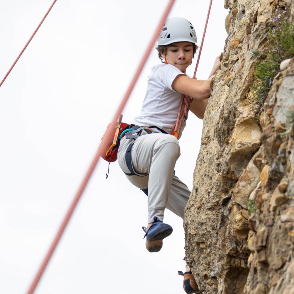 enfant faisant de l'escalade en falaise